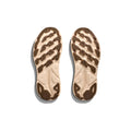 The Hoka M Clifton 9 in Wheat/Shifting Sand features beige and brown athletic soles designed for cushioning and a responsive toe-off, shown from the bottom against a white background. Inspired by the comfort of Clifton 9.