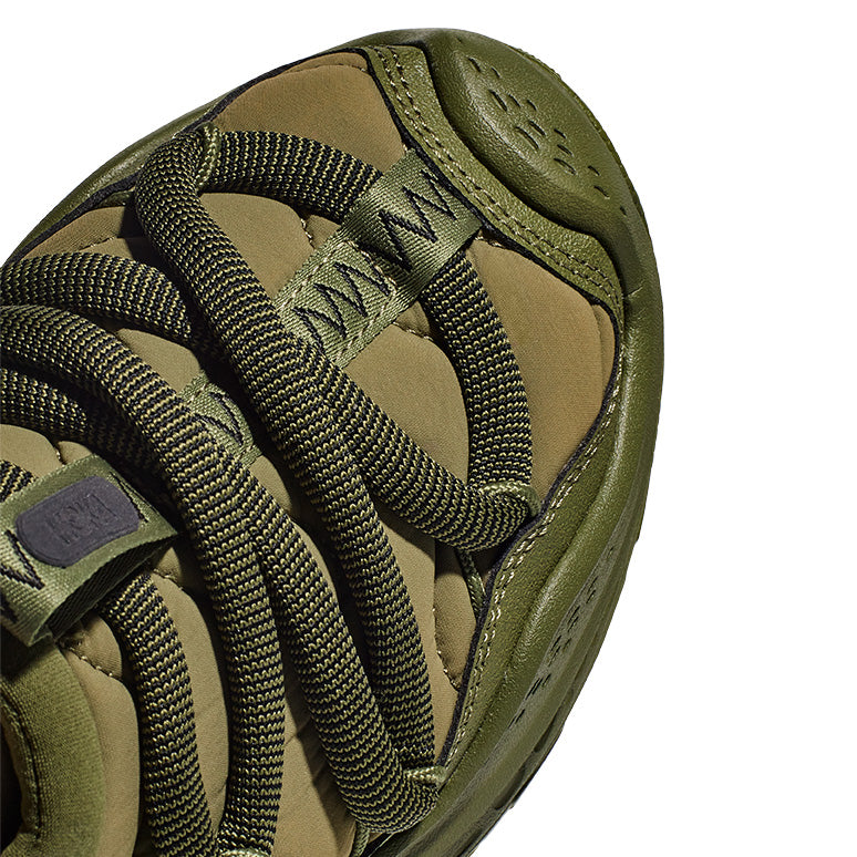 Close-up of the green Hoka U Ora Primo sneaker featuring wide, crisscrossed laces and a textured upper, ideal for a lifestyle centered on recovery and slip-on comfort.