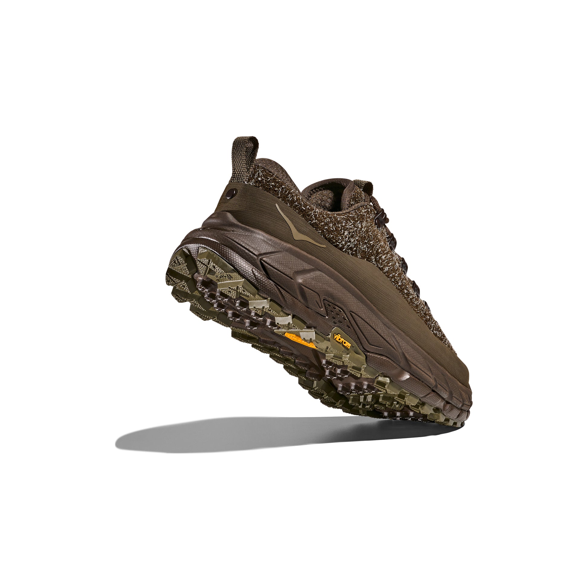 The Hoka U Tor Summit TP athletic shoe is shown from the side, angled upwards, showcasing its textured sole reminiscent of rugged hiking boots and intricate knit pattern.