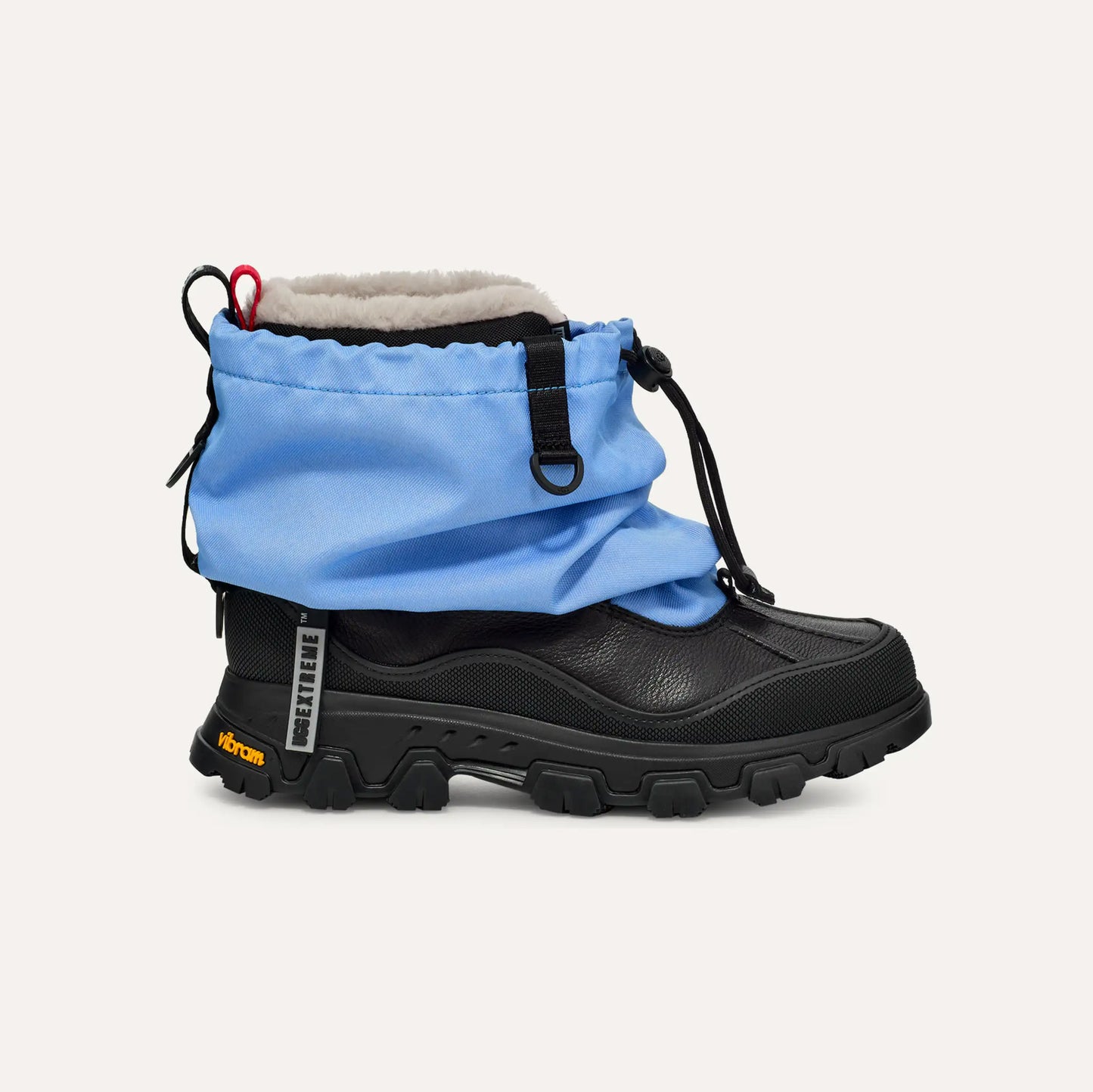 The Ugg W Metropeak is a black and blue winter boot with a rugged sole, drawstring closure, and shearling lining for comfort. This waterproof design offers an elegant side view.