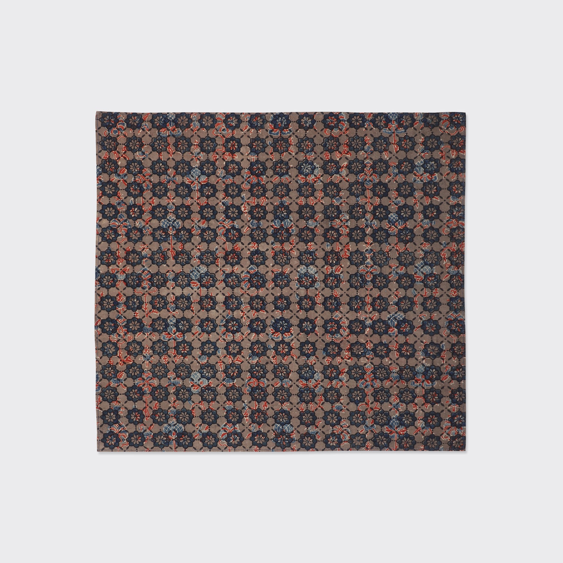 Kardo Bandana 21" x 21", Ajrakh 23 features a square fabric with a repeating geometric floral pattern in red, blue, and beige on a brown background.