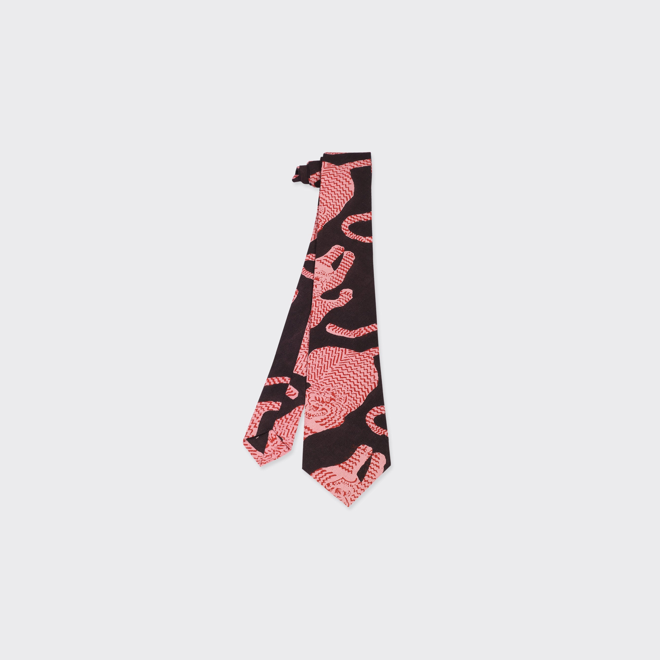 The Kardo Tie, Coral Block Print, is displayed flat on a white background and showcases a striking black base with bold red abstract patterns.