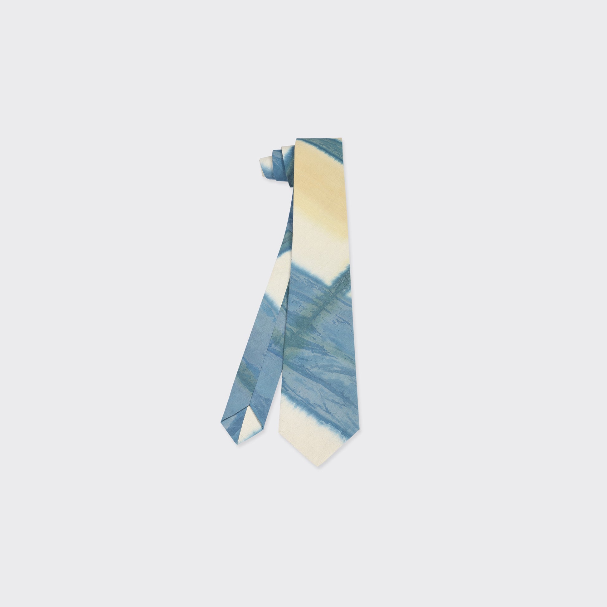 The Kardo Tie, Yellow Clamp Dye, features a blue, yellow, and off-white abstract diagonal pattern and is displayed against a plain light background.