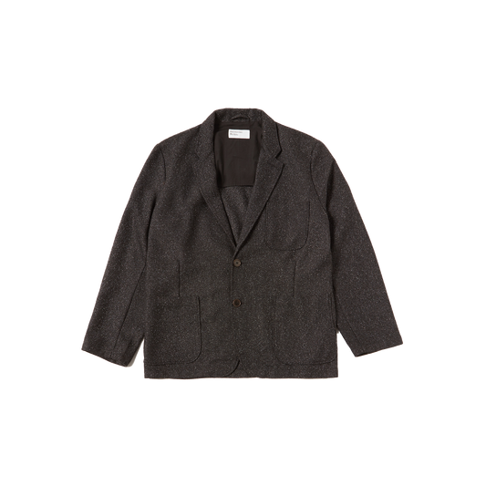 The Universal Works 2 Button Jacket is a sleek dark gray blazer with dual buttons and front pockets, elegantly displayed on a white background.