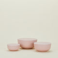 The Hawkins New York Essential Lidded Bowls, a set of three in pink ceramic and crafted for perfect stackability, are arranged against a plain cream background.
