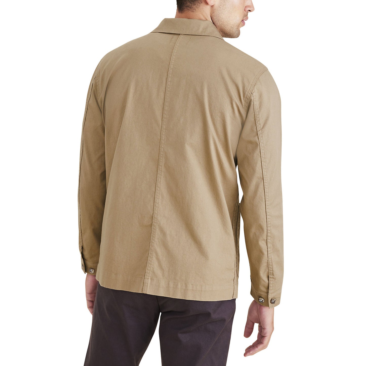 Rear view of a person in Dockers Men's Chore Coat, beige and made from recycled nylon, paired with dark pants against a white background.