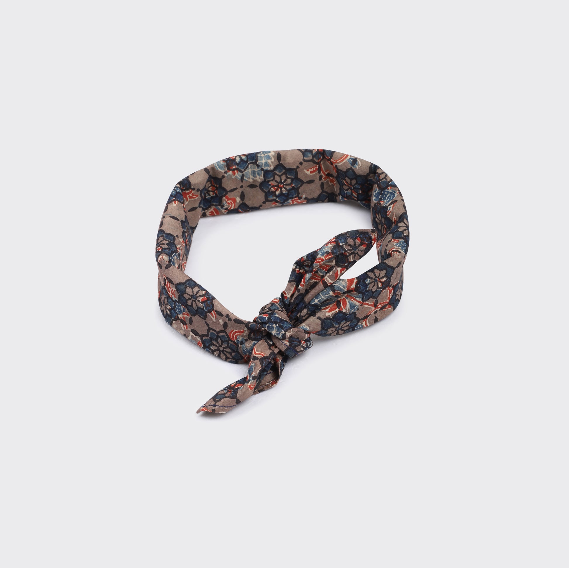 Kardo’s Bandana 21" x 21", Ajrakh 23 features a knotted front and a floral pattern in brown, blue, and red tones, shown against a plain light background.