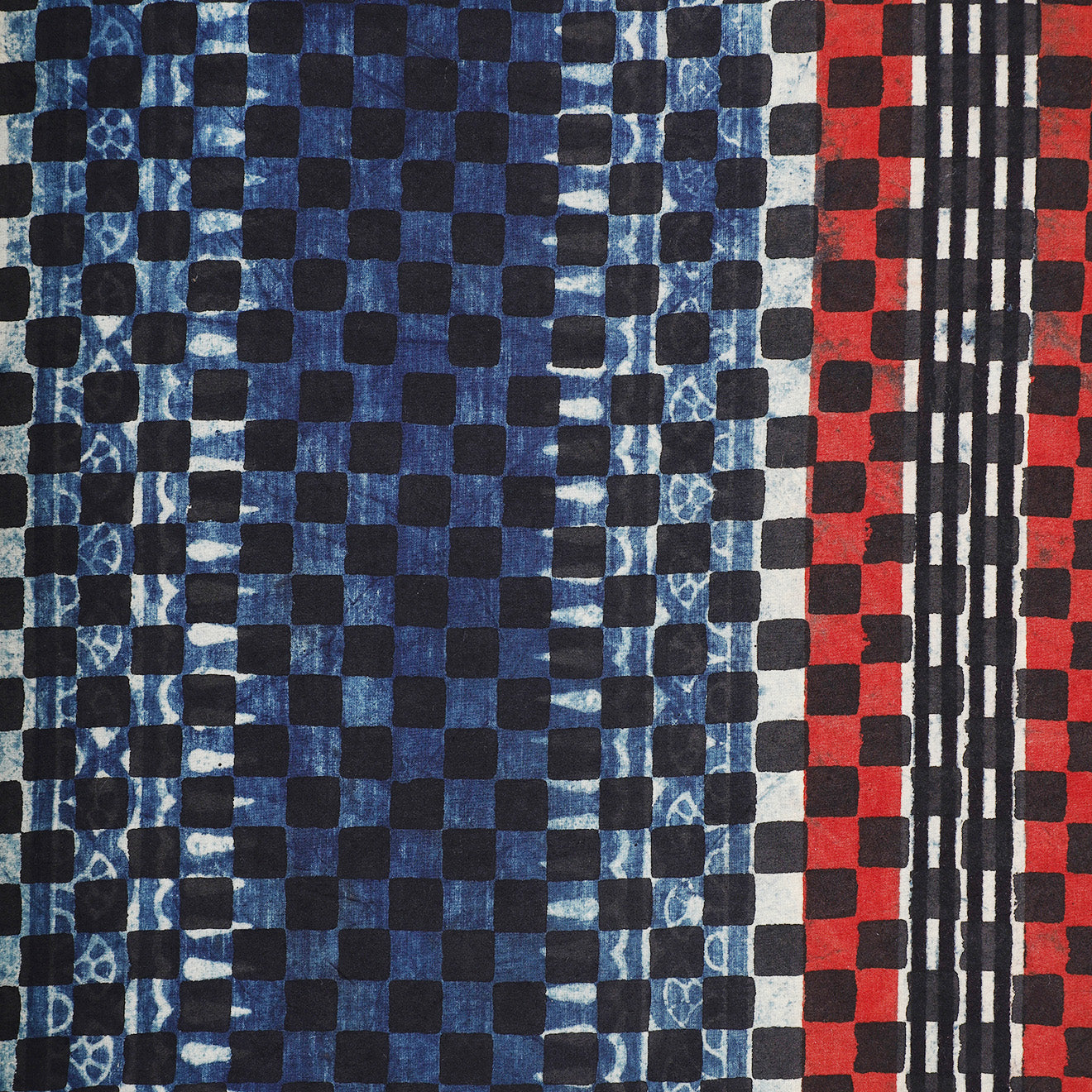 Kardo’s “Ajrakh 22” Bandana (21" x 21") features a grid of black squares with blue and red tie-dye sections and vertical black lines on the red side.