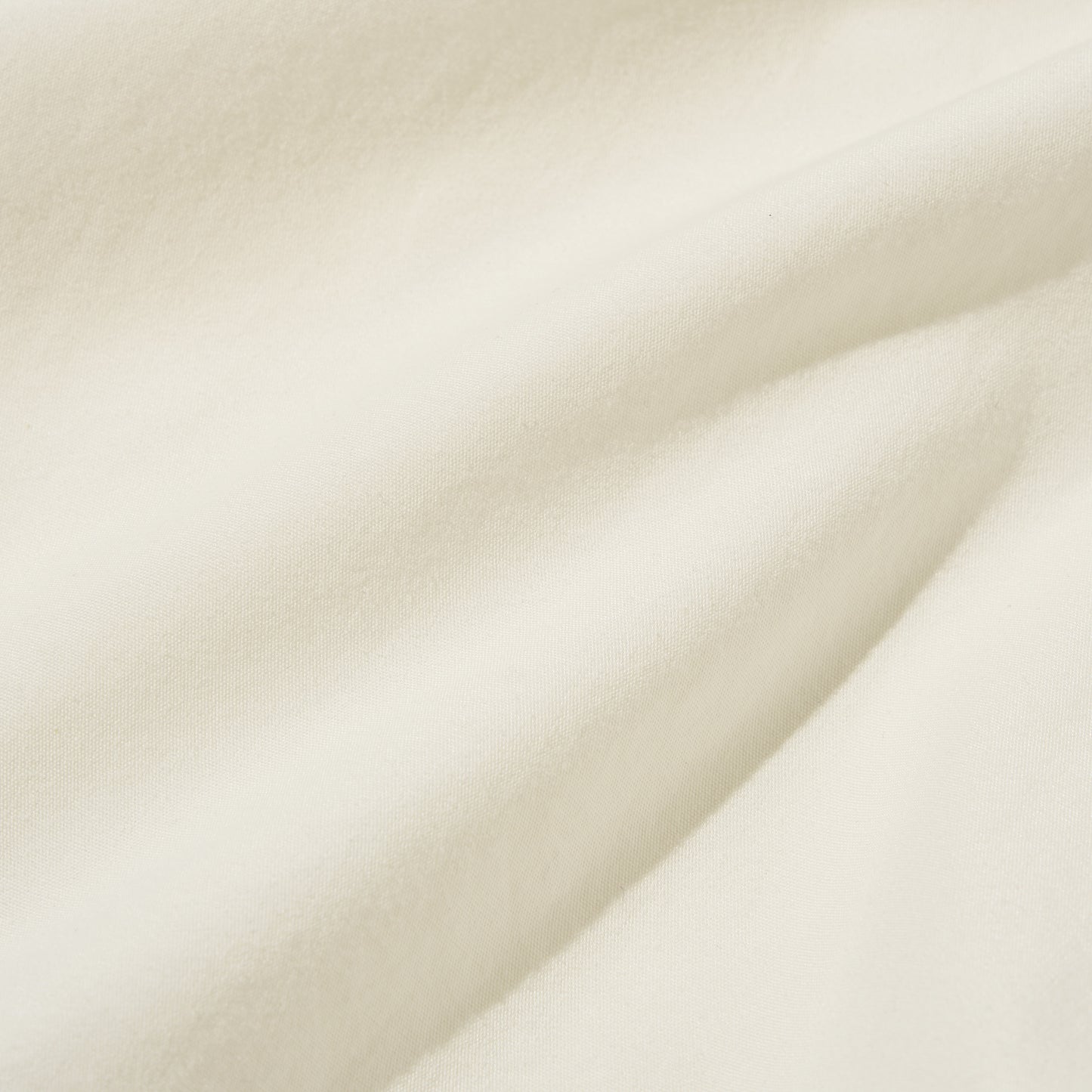 Close-up of the Universal Works Gardenia Lycot Camp Shirt in ecru, featuring soft, off-white fabric with gentle folds and a smooth texture.