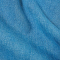 Close-up of the Universal Works Herringbone Recycled Kyoto Work Jacket in Washed Indigo, showing its blue denim fabric with a chevron herringbone pattern and visible diagonal texture.