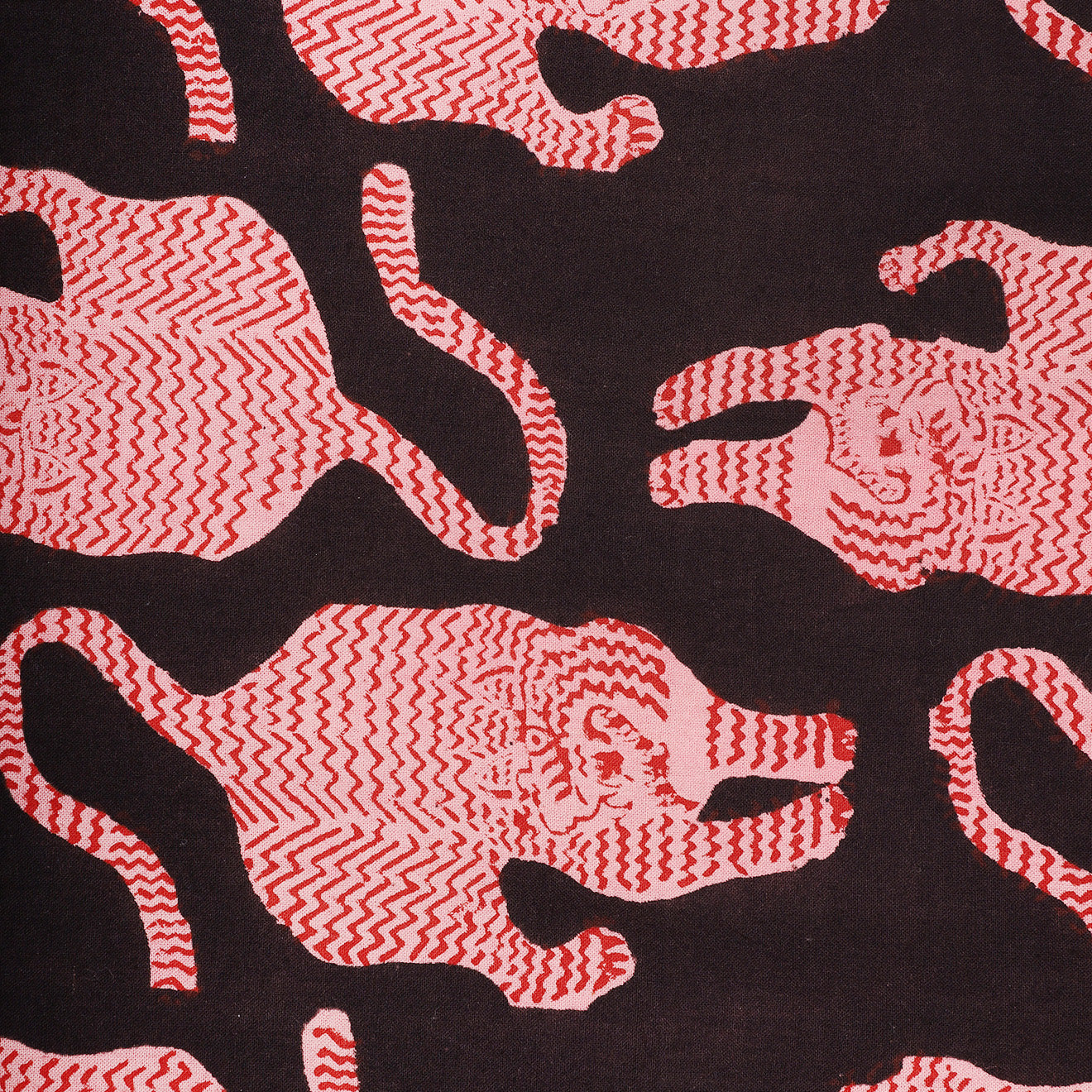 The Kardo Bandana 21" x 21", Coral Block Print, features stylized red and pink tiger motifs with zigzag patterns repeated across a dark background for a bold, graphic look.