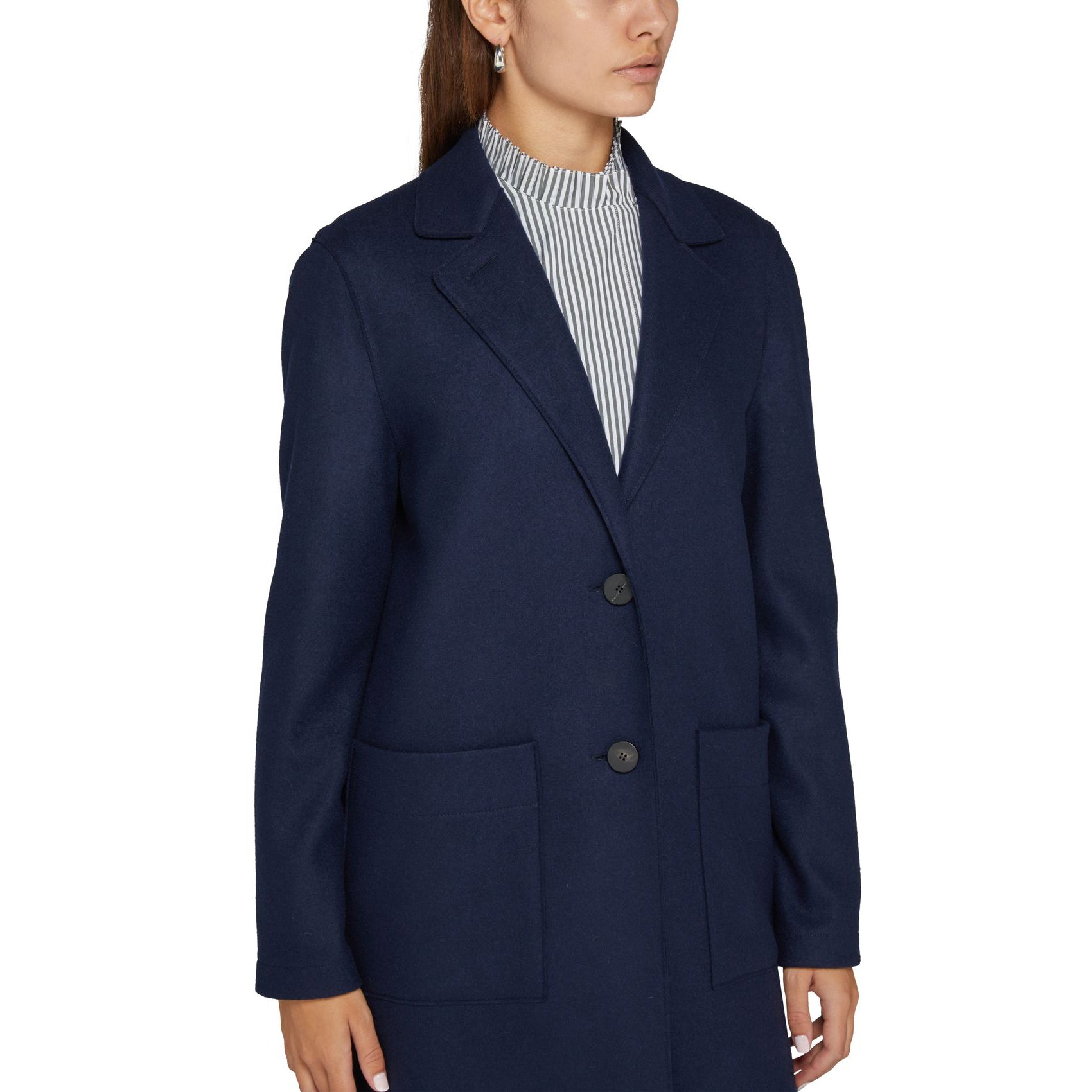 A person is wearing the Harris Wharf W Long Boxy Coat Cashmere in navy, characterized by its large pockets and two visible buttons, over a striped shirt.