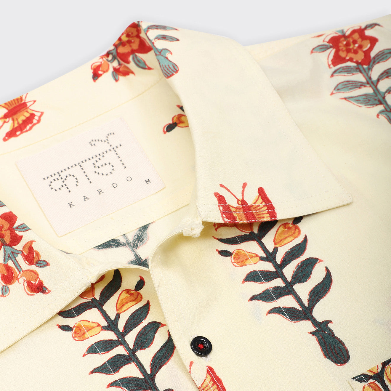 Close-up of the Kardo Chintan SS Shirt, Block Print 138—a cream collared shirt featuring red and yellow floral prints with a visible brand label inside.