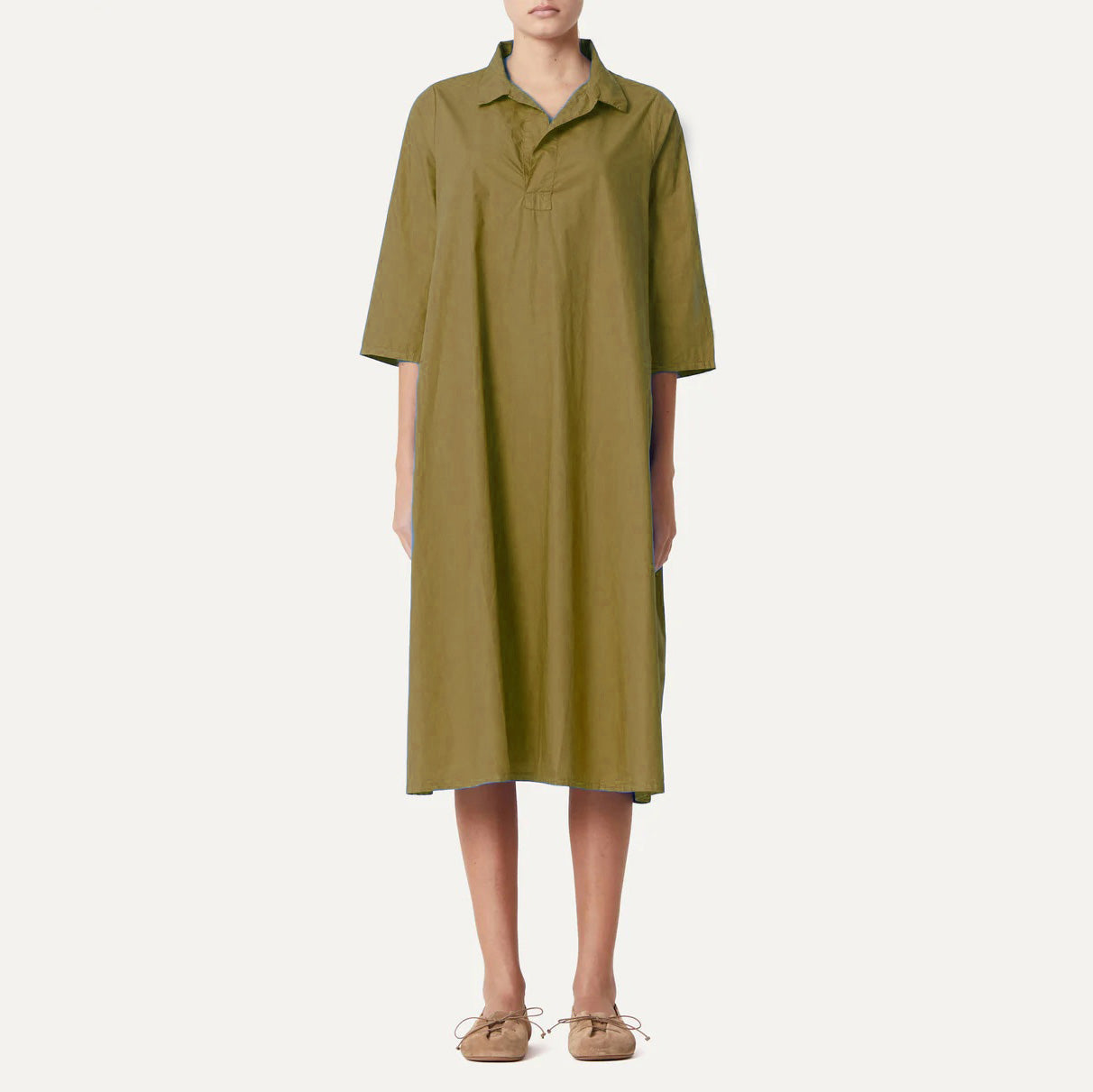 A person wearing the Labo Art Abito Pepe Dress, Clara, a long olive-green poplin dress with elbow sleeves, paired with beige shoes, stands against a plain white background.
