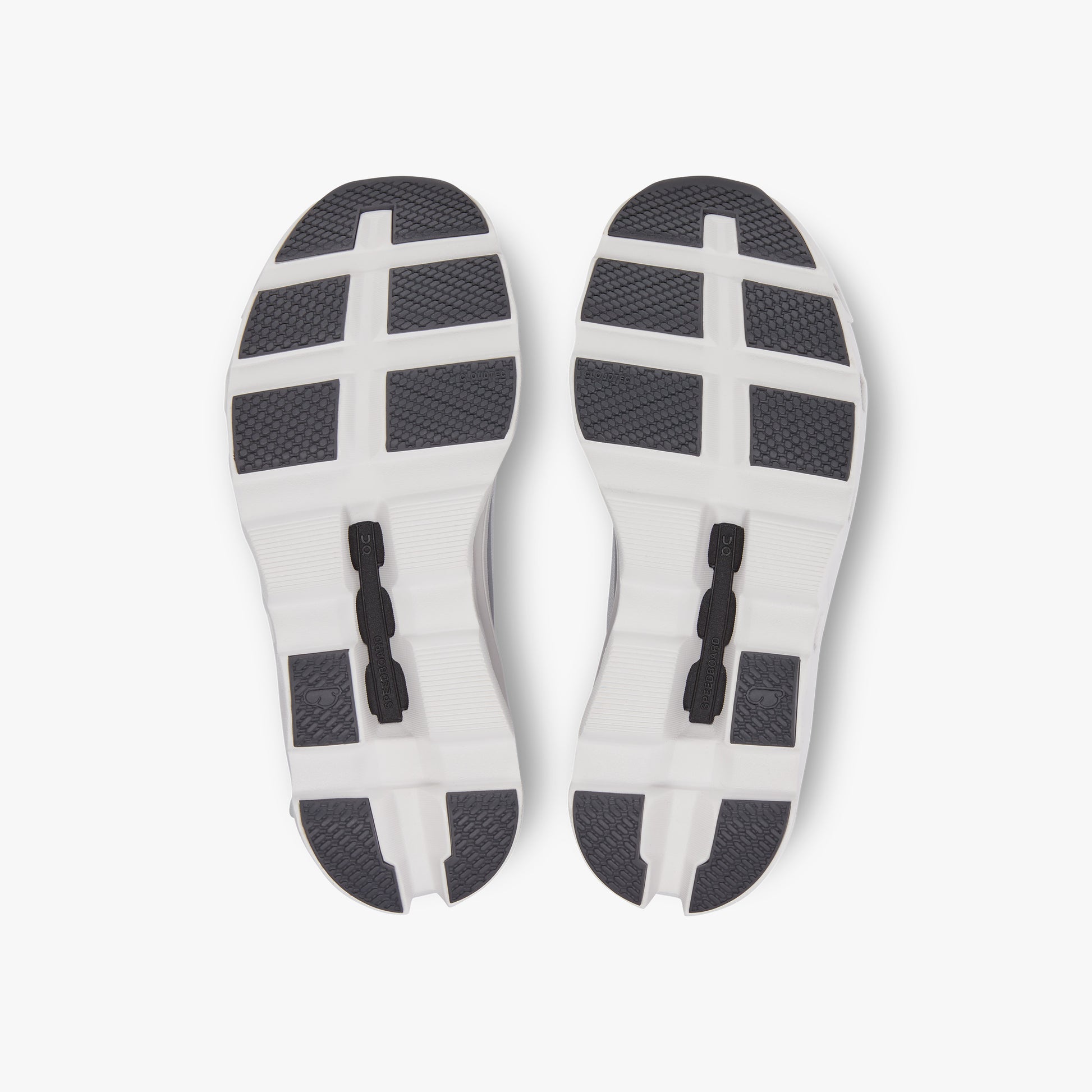 Overhead view of the all-white soles of On Running M Cloudmonster shoes, highlighting textured tread patterns, flex grooves, and Helion™ superfoam for superior comfort.