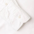 Close-up of the Gitman Vintage Classic White Oxford's cuff, featuring two white buttons, laid on a white surface.