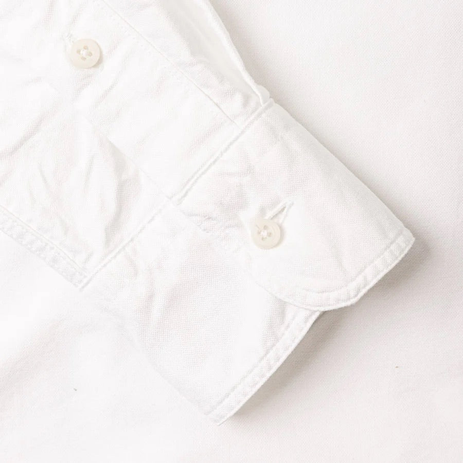 Close-up of the Gitman Vintage Classic White Oxford's cuff, featuring two white buttons, laid on a white surface.