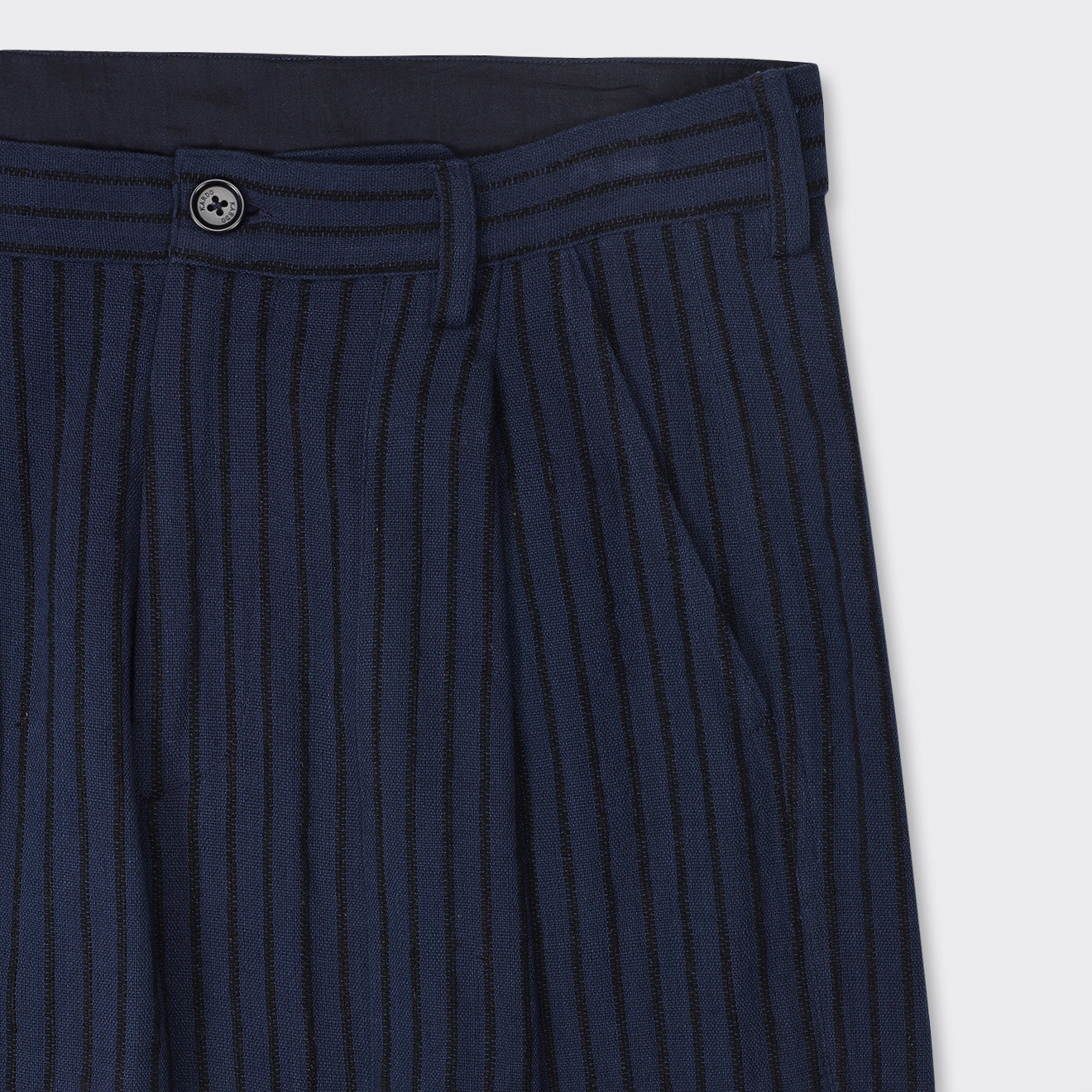 Close-up of the waist and upper leg of Kardo's Yuki Pleated Trousers in Blue Black Stripe, featuring vertical stripes, belt loops, button closure, and side pockets.
