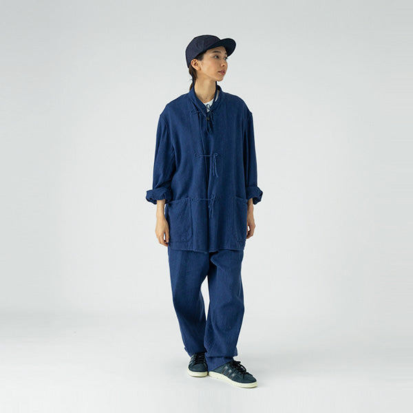 Wearing the Sublime Roe Charidoor Cap, along with a loose-fitting navy blue top and matching pants, a person stands against a plain light background.