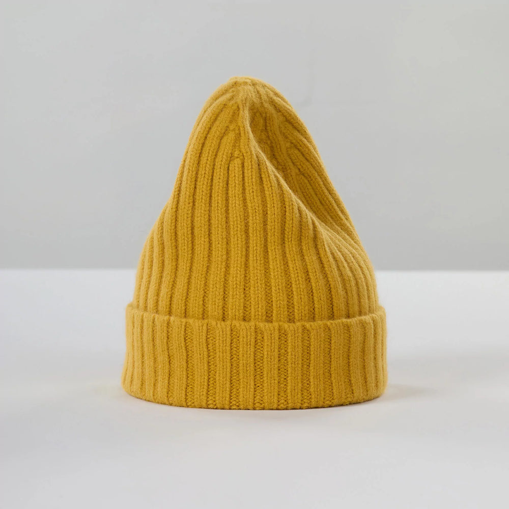 The Large Beanie in mustard by Le Bonnet is displayed upright on a neutral background, showcasing its chunky knit design with a folded brim for maximum comfort.