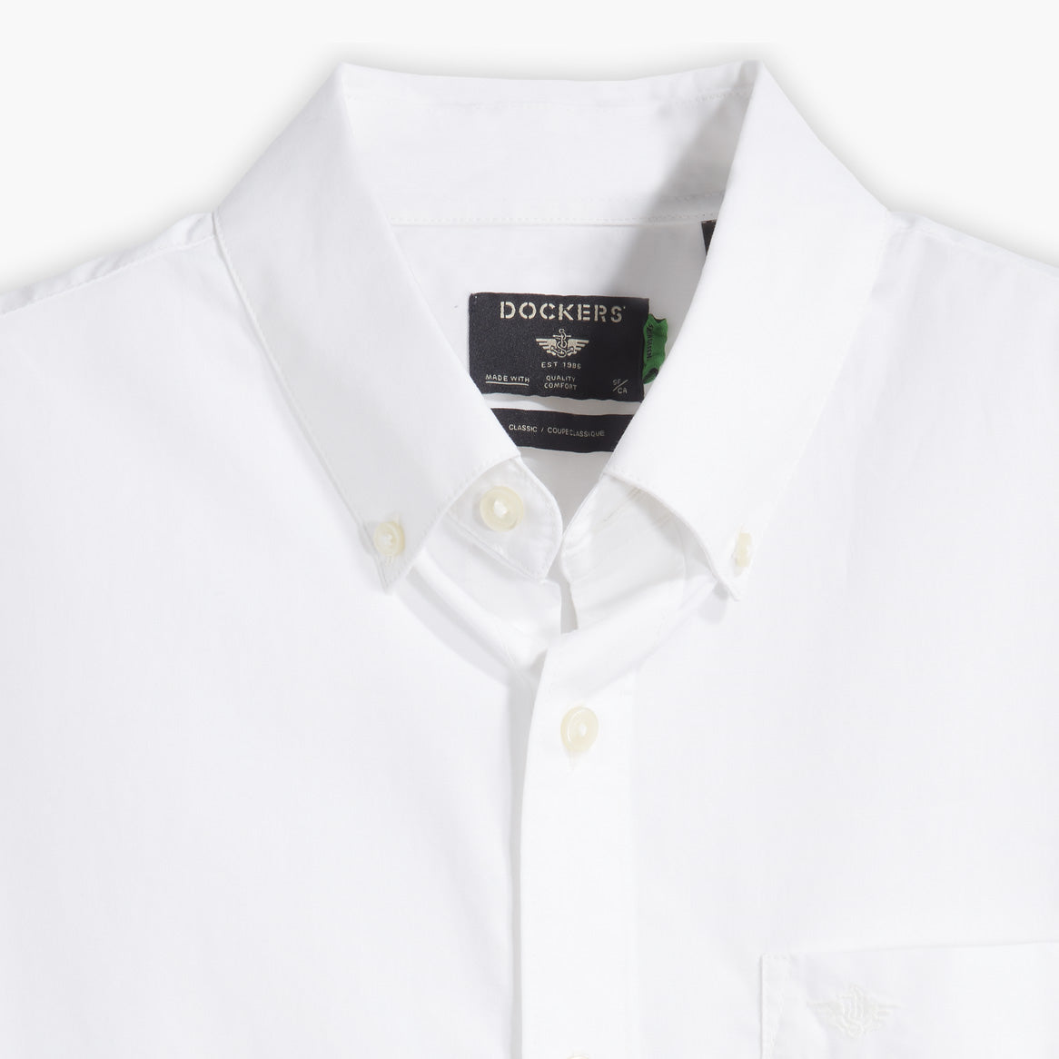 Close-up of a Men's Signature Shirt with Stain Defender by Dockers, featuring a white button-down design, Comfort Flex Collar, and a visible black Dockers label inside the collar.