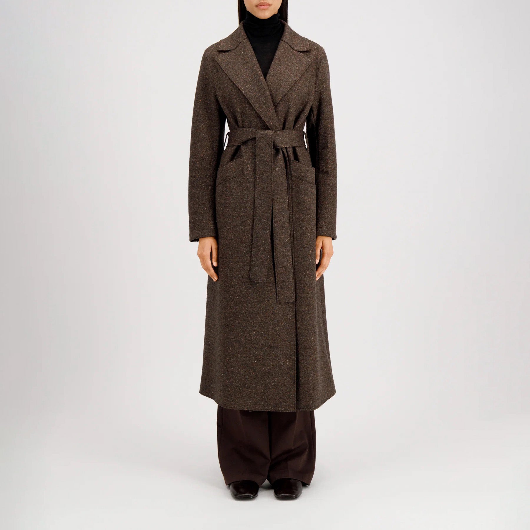 A person in the Harris Wharf W Long Maxi Coat Donegal stands against a plain white background, wearing dark pants and black shoes.