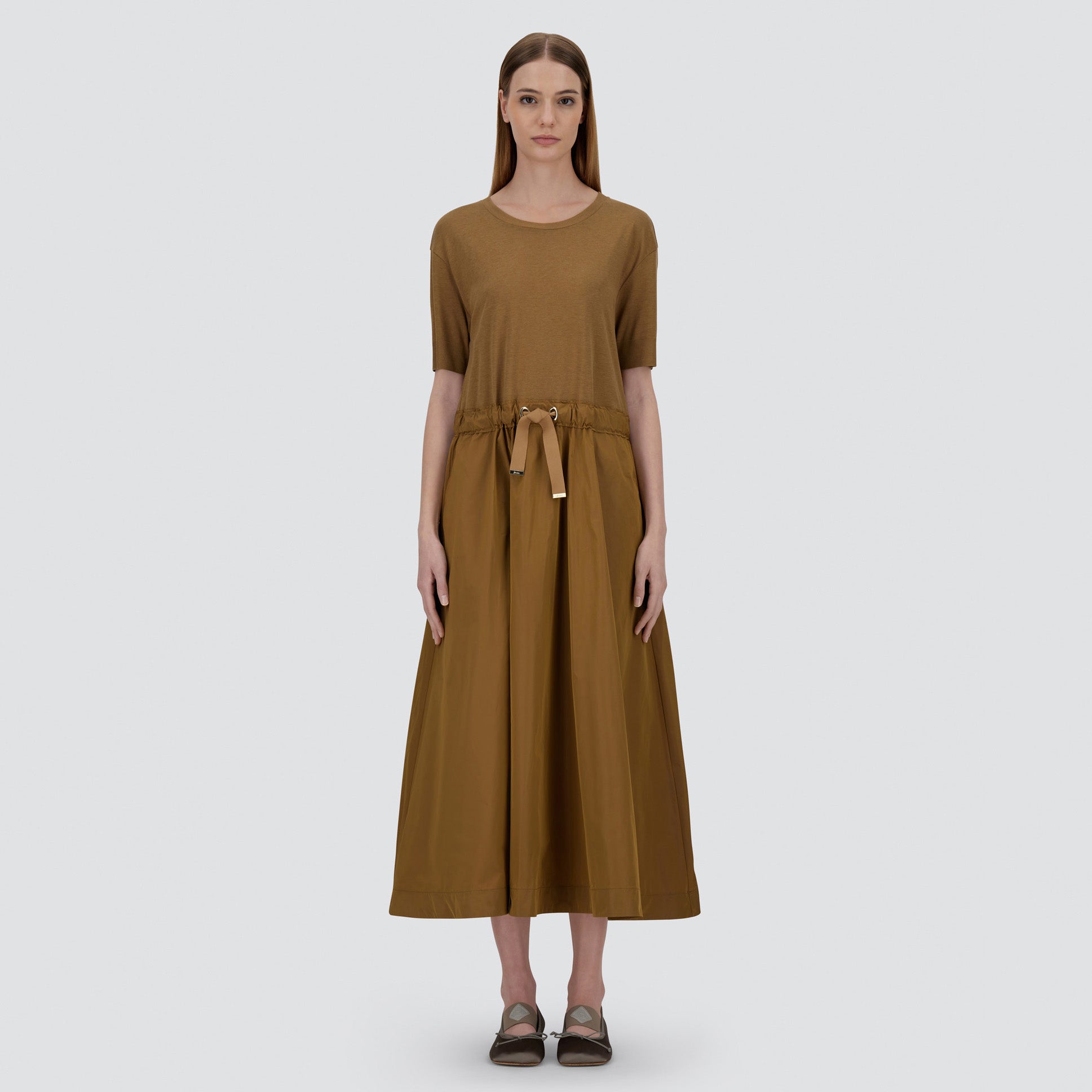 A woman stands facing forward in the Herno Glam Knit and Taffeta Easy Dress, featuring a minimalist design in brown against a plain background.