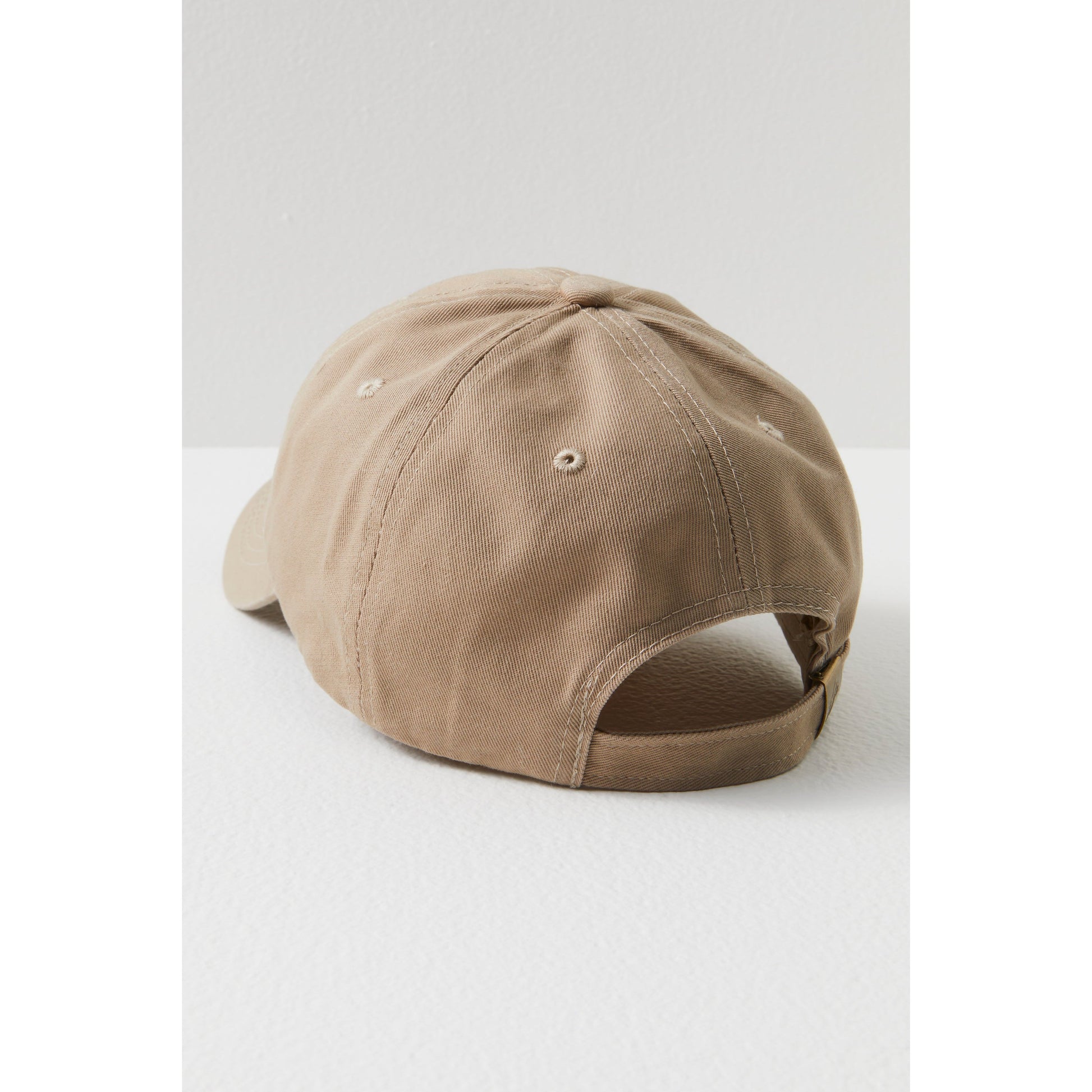 A beige Big Buti Baseball Cap with Free People Movement logo stitching details and adjustable fit, displayed side-view against a white background.
