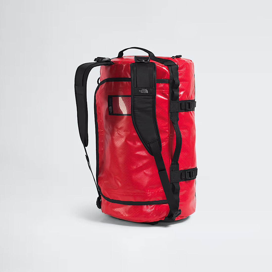 The North Face Base Camp Duffel in TNF Red features black straps, buckles, side and top handles, and a small exterior zip pocket. This waterproof duffel is built for every adventure.