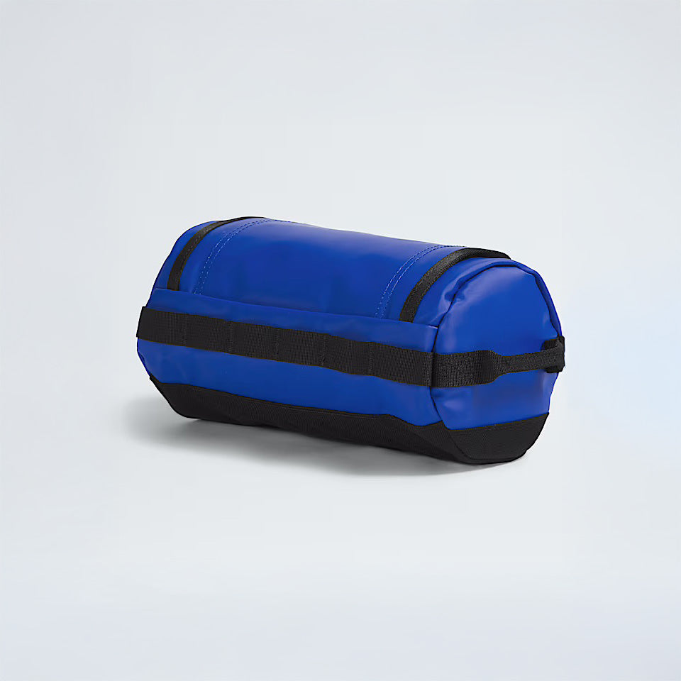 The North Face Base Camp Travel Canister L in Blue/TNF Black features a durable, water-repellent recycled TPE laminate and black accents, shown on a plain light background.