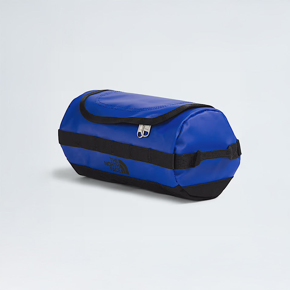 A blue North Face Base Camp Travel Canister S with a zippered top compartment, shown on a plain light gray background.