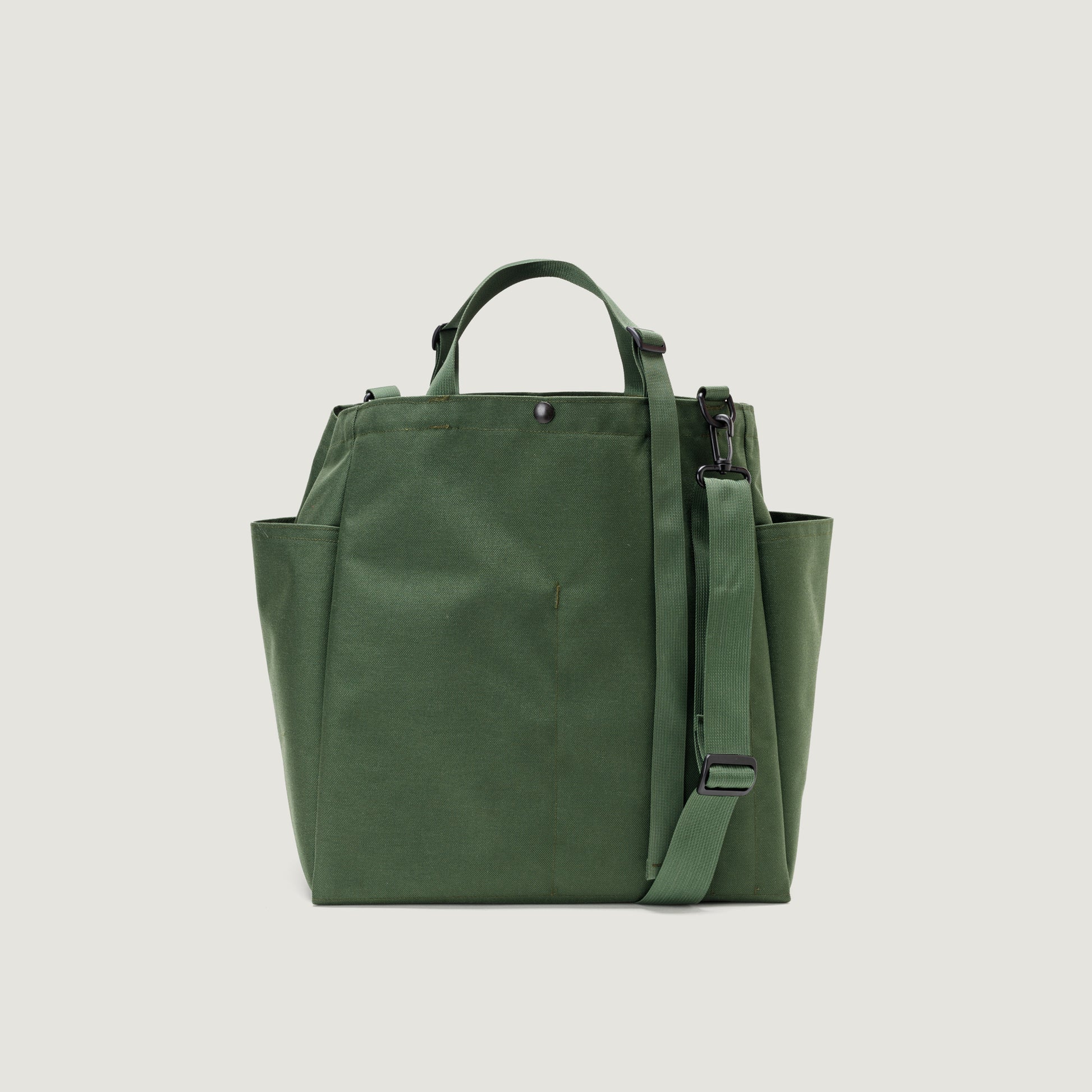 The Carry All Beach Bag by Bags in Progress is a green nylon tote with two short handles, a detachable shoulder strap, and side pockets, shown against a plain light background.