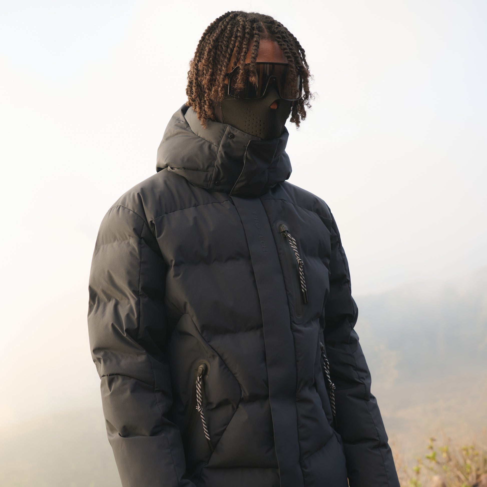 Person wearing a dark puffer jacket with a blurred background