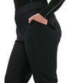 A person wearing the Emma Pant by Halfdays in a slim-fit black style, with their hand in a zippered pocket.