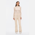 A person in a cream-colored slim-fit long-sleeve top and matching Halfdays Emma Pant poses against a plain white background.