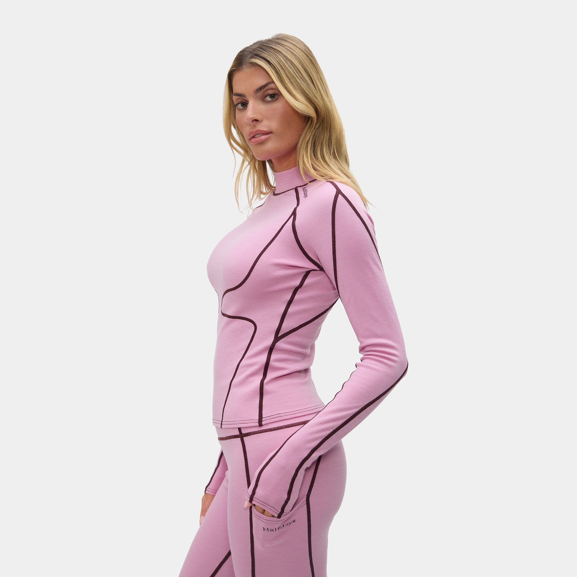 Woman wearing a pink outfit with black accents on a white background