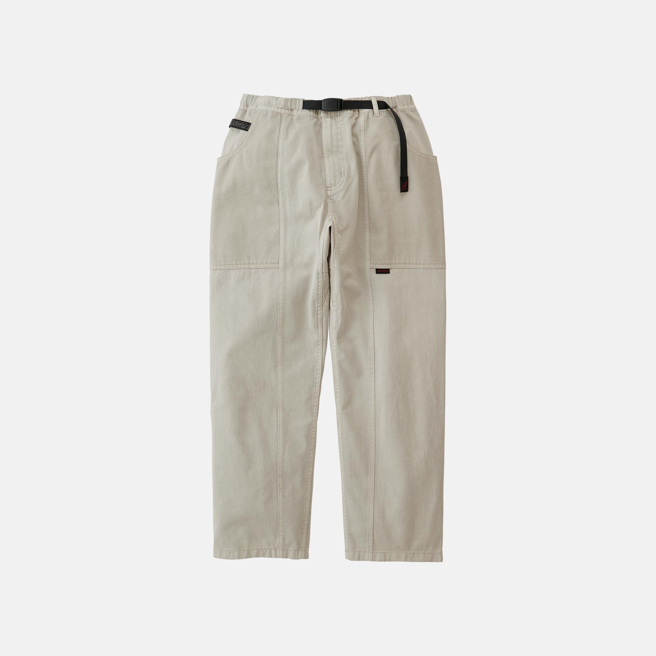 The Gadget Pant by Gramicci features an elastic waistband, built-in black belt, two side pockets, and knee stitching detail in a beige cargo style.