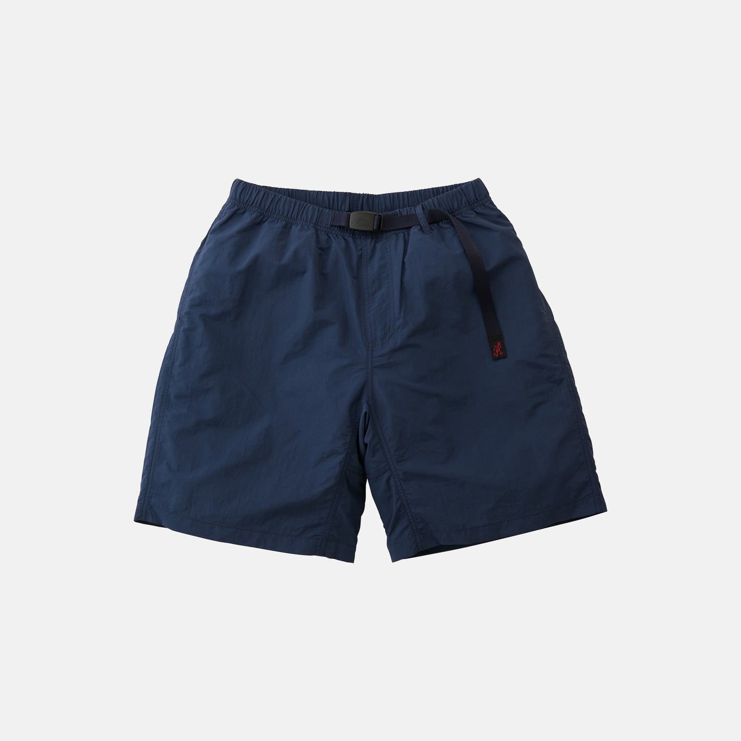 The Gramicci Nylon Loose Short in navy blue features wind-resistant, water-repellent nylon, an elastic waistband with adjustable belt, and side pockets, shown against a plain white background.