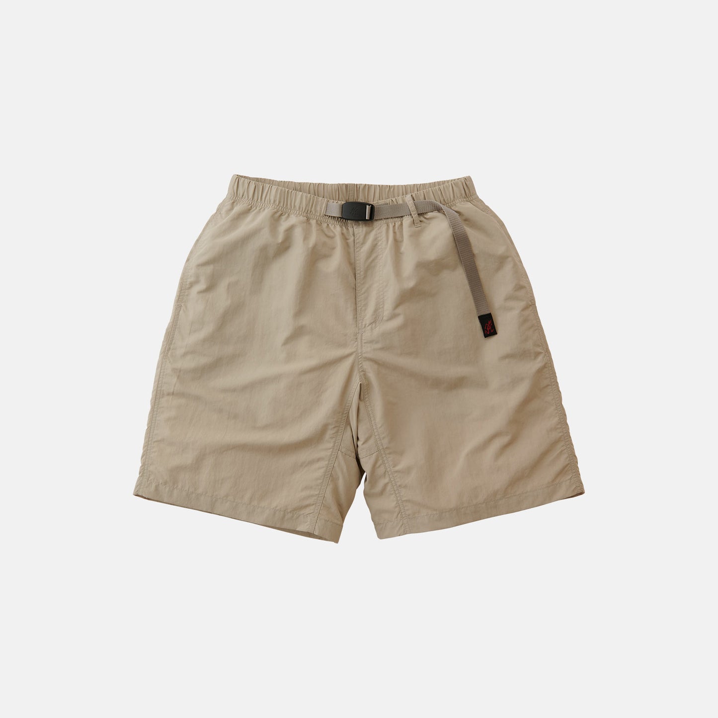 The Gramicci Nylon Loose Short is a light beige, knee-length nylon short with an elastic waistband, integrated adjustable belt, and water-repellent finish, shown on a plain white background.