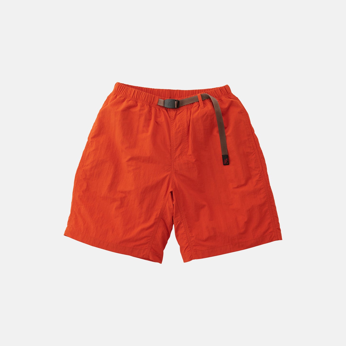 Gramicci Nylon Loose Short in bright orange, made of water-repellent nylon, features an elastic waistband with a black adjustable belt and is displayed flat on a plain white background.