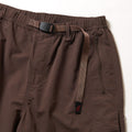 Close-up of Gramicci Nylon Runners in brown, showcasing an adjustable belt with a plastic buckle and a zippered side pocket, set against a white background.