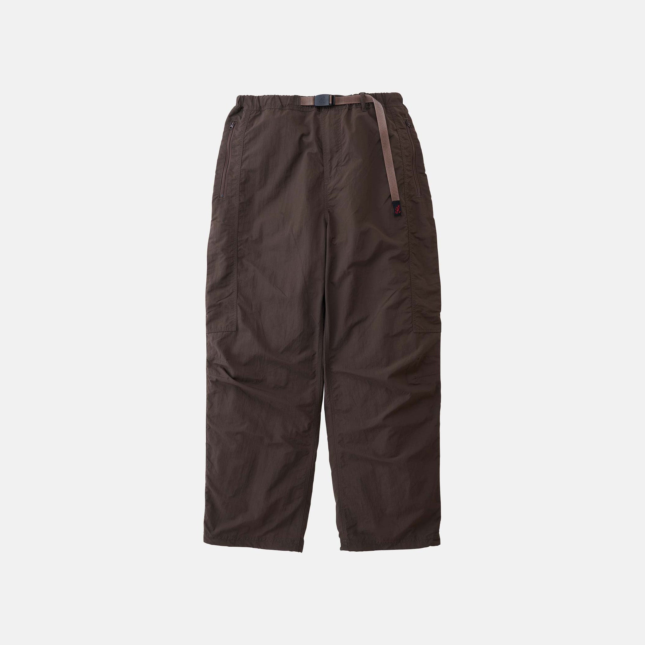 The Gramicci Nylon Runners are loose-fitting, dark brown pants with an adjustable waist belt, shown against a plain white background.