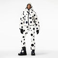 A person in the Goldbergh Grand Ski Jacket, Dot Cream, paired with matching ski pants, beanie, gloves, and waterproof boots stands against a plain backdrop.