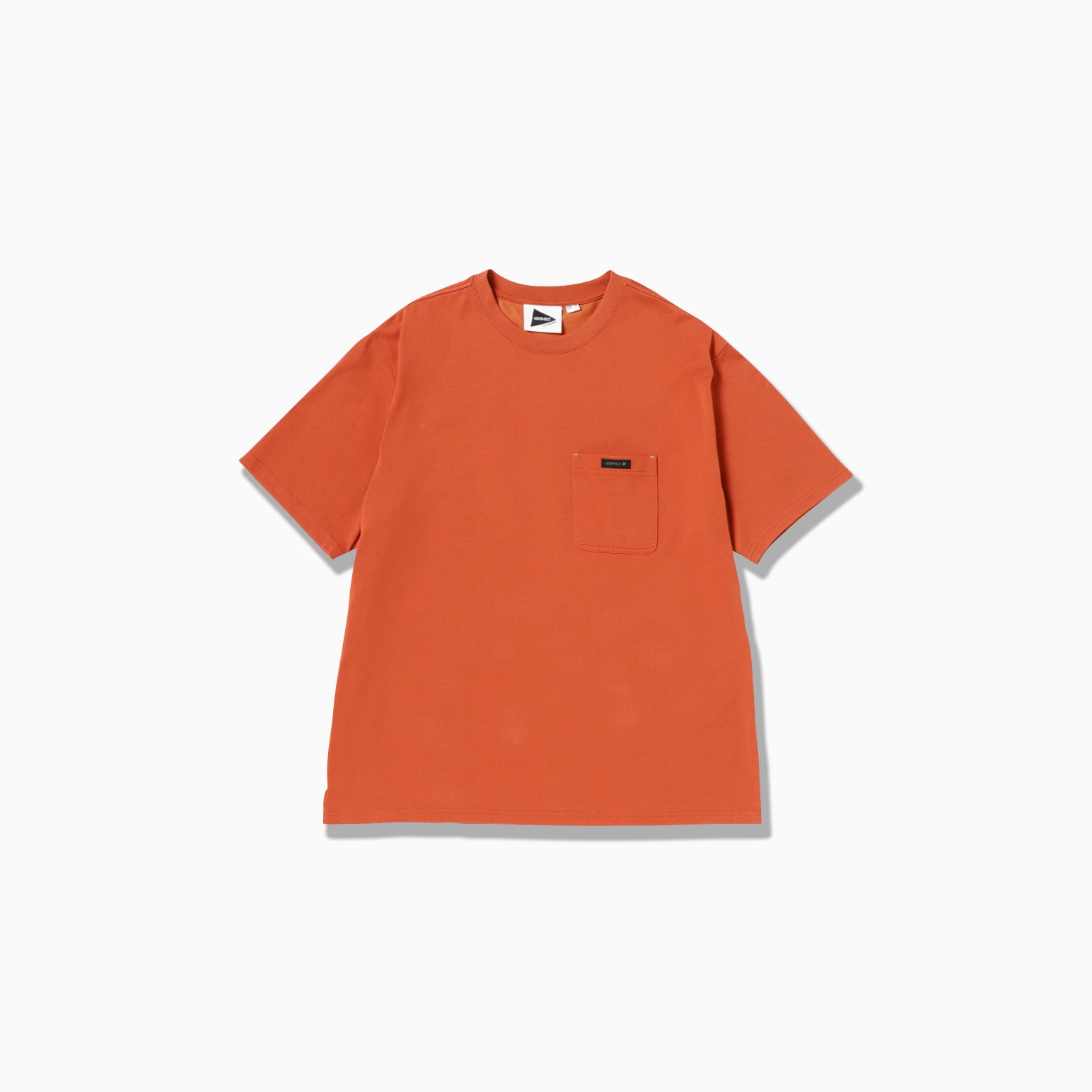 Gramicci x And Wander's Backprint Tee: an orange short-sleeve t-shirt featuring a small left chest pocket, shown on a plain white background.