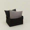 The Essential Low Basket by Hawkins New York holds two square pillows (dark and light gray) against a plain background—ideal for minimizing clutter or storing blankets stylishly.