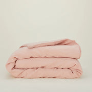 The Hawkins New York Simple Linen Bedding - Queen Duvet Cover in pale pink is neatly folded and displayed against a plain off-white background.