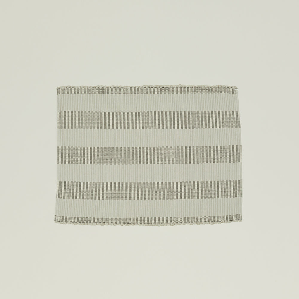 The Hawkins New York Essential Floor Mat, Light Grey, is made from 100% recycled fibers and features alternating light gray and white horizontal stripes for a subtle pop of color. It's machine washable for easy care.
