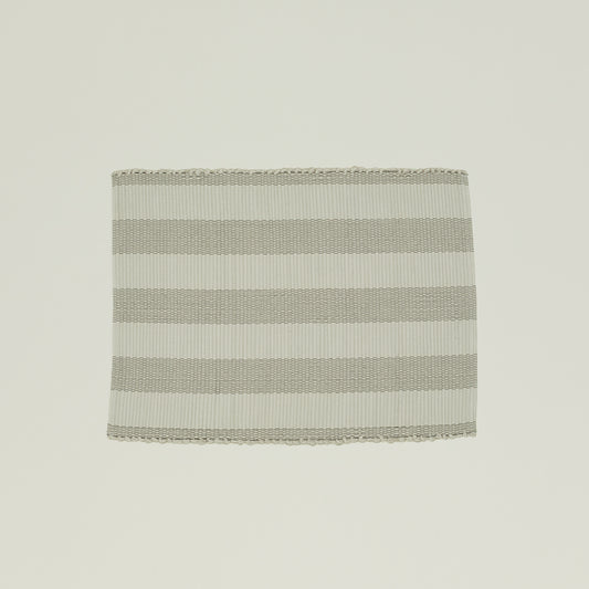 The Hawkins New York Essential Floor Mat, Light Grey, is made from 100% recycled fibers and features alternating light gray and white horizontal stripes for a subtle pop of color. It's machine washable for easy care.