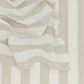 These beige and white striped placemats from Hawkins New York's Essential Collection feature partially draped folds, perfect for embodying an easy living vibe.