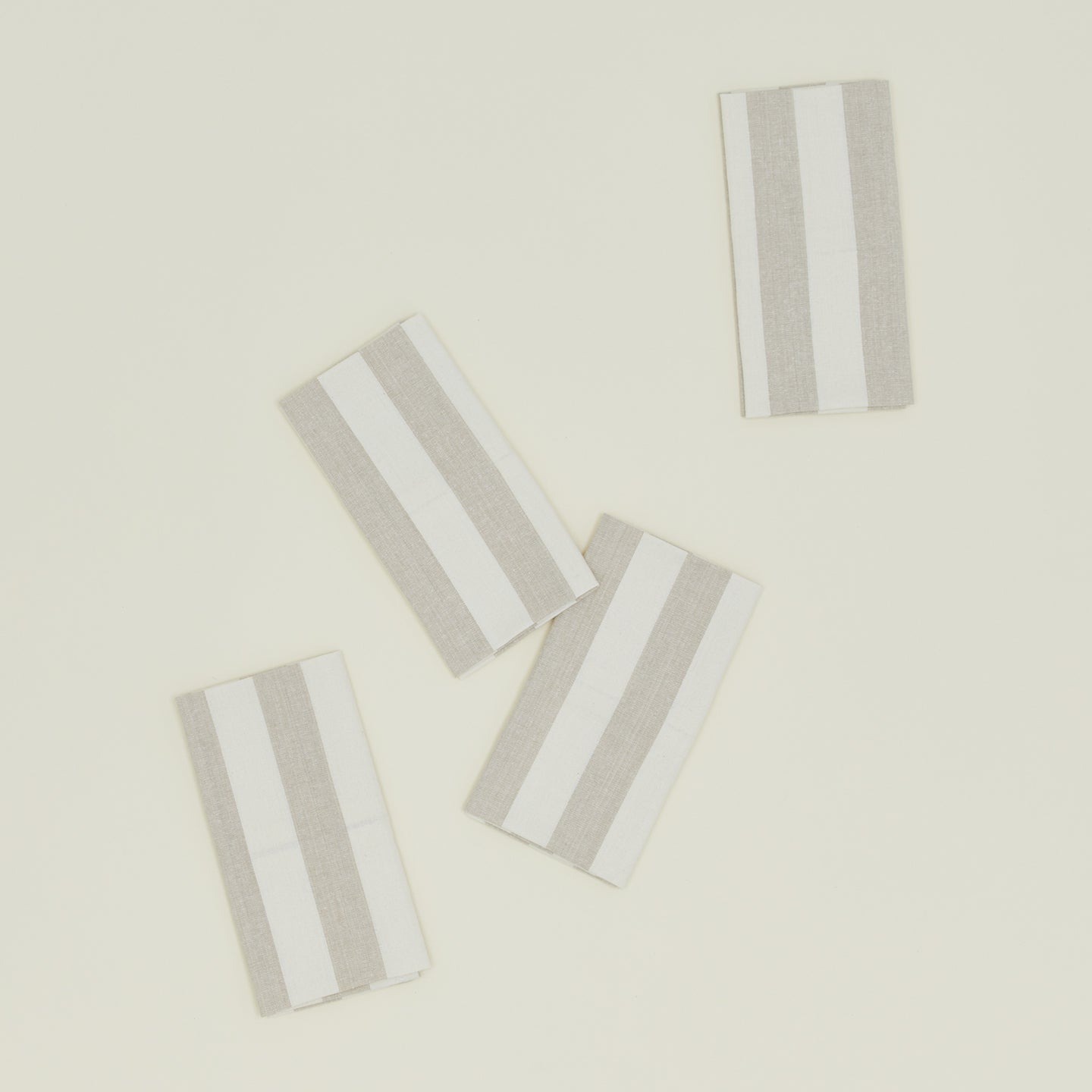 These Hawkins New York Essential Striped Placemats, set of four, are elegantly arranged on a light beige surface, embodying easy living.